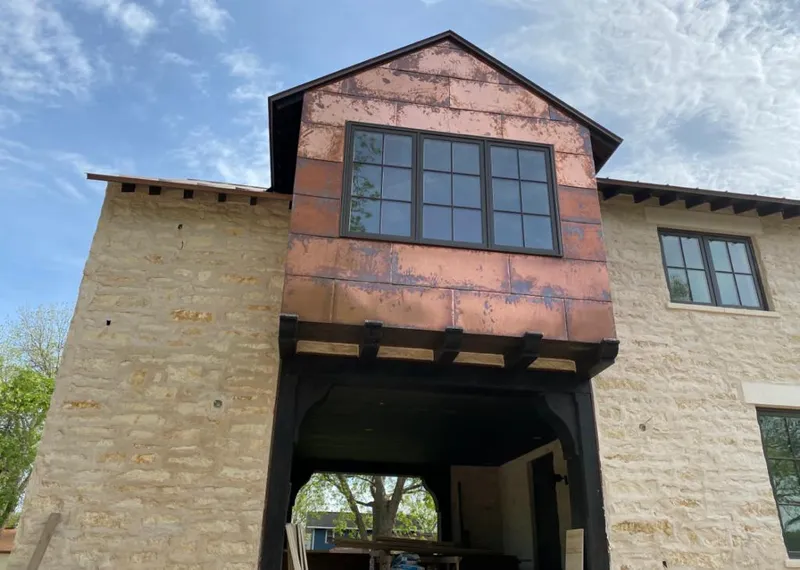 Copper metal panel facade on a stone building for Skylight Installation in McNair