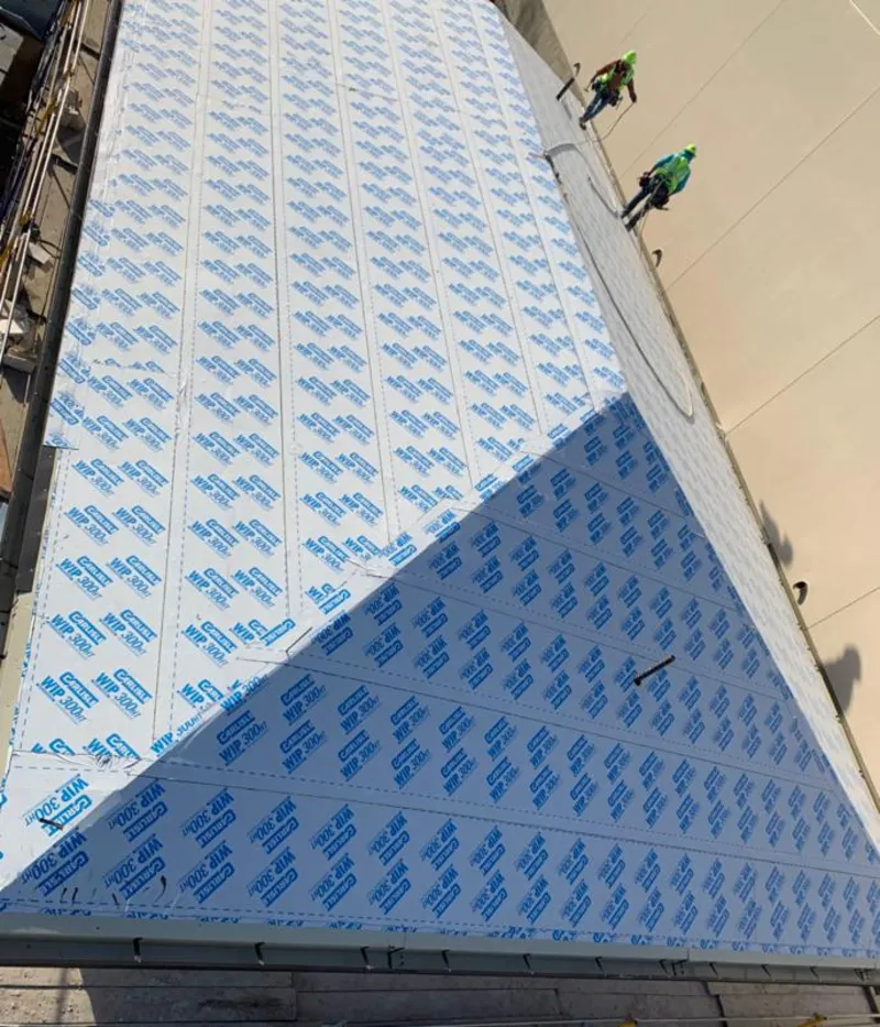 Professional roofers installing underlayment on a metal roof in McNair